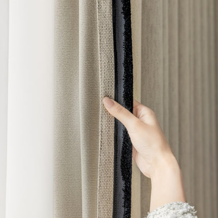 a person's hand is holding a curtain in front of a window