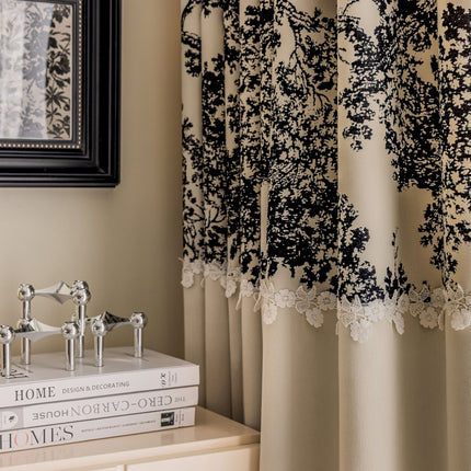 a black and white lace curtain hanging on the side of a window