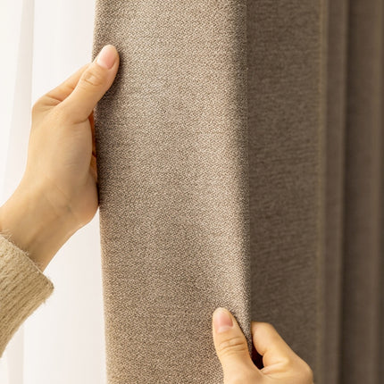 a person holding a curtain with their hand