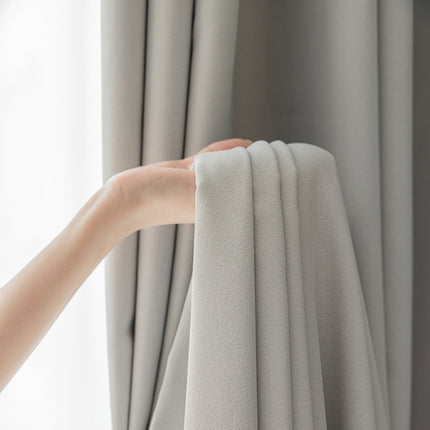 a person holding a curtain with their hand