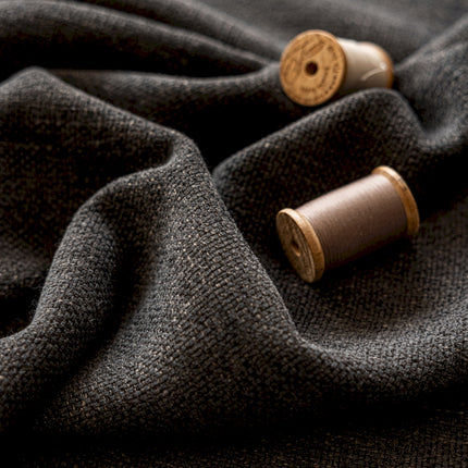 two spools of thread sitting on top of a gray cloth