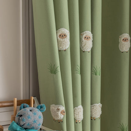 a teddy bear sitting next to a curtain with sheep on it