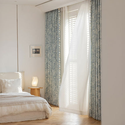 a bedroom with a white bed and blue curtains