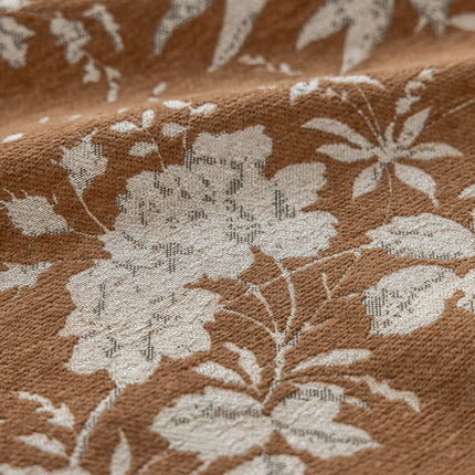 a close up of a brown and white flowered fabric