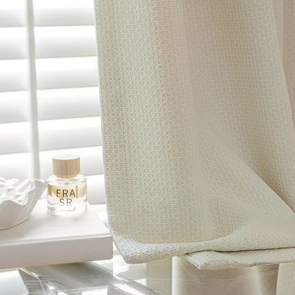 a white shower curtain with a bottle of perfume next to it