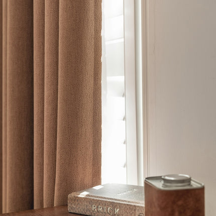 a book sitting on top of a wooden table next to a window