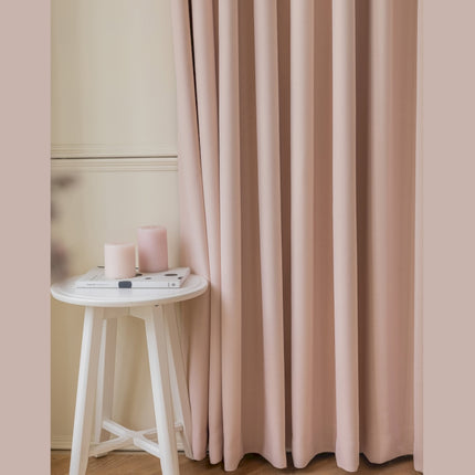 a white table sitting next to a pink curtain