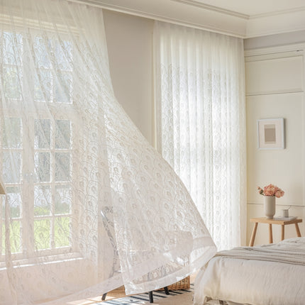 a bedroom with a bed and a white curtain
