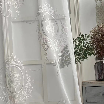 a white curtain with a floral design on it