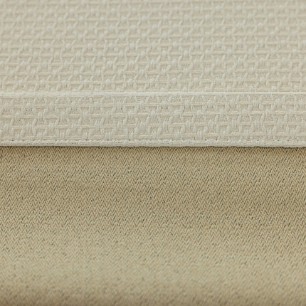 a close up of a bed with a beige cover