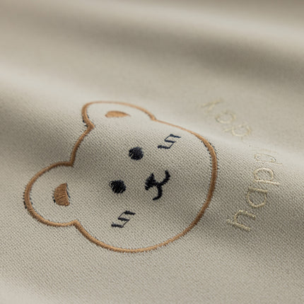 a close up of a teddy bear on a white shirt