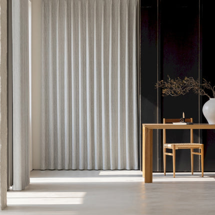 a room with a table, chair and a vase