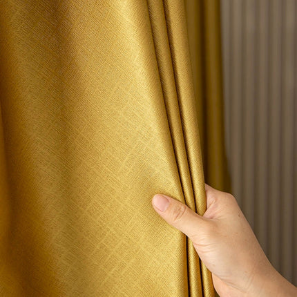 a hand holding a curtain with a gold color