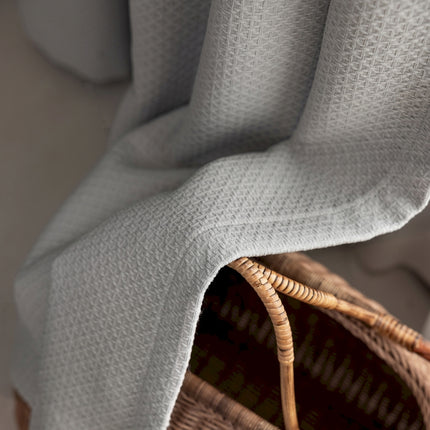 a wicker basket with a blanket on top of it