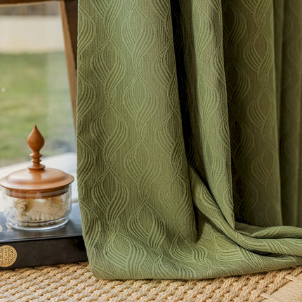 a window with a green curtain next to a window sill