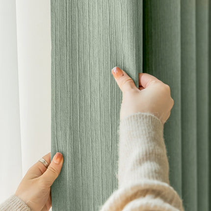 a woman is holding a curtain with her hand
