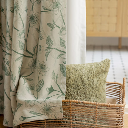 a basket sitting next to a window with a curtain