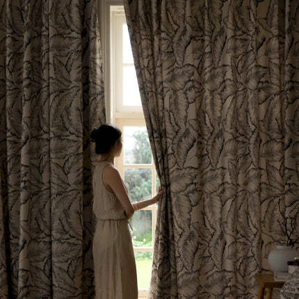 a woman standing in front of a window looking out
