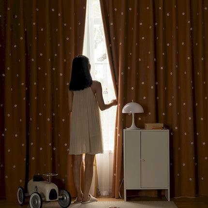 a woman standing in front of a window next to a toy car