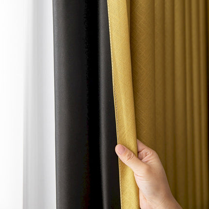 a hand holding a curtain with a black and yellow color