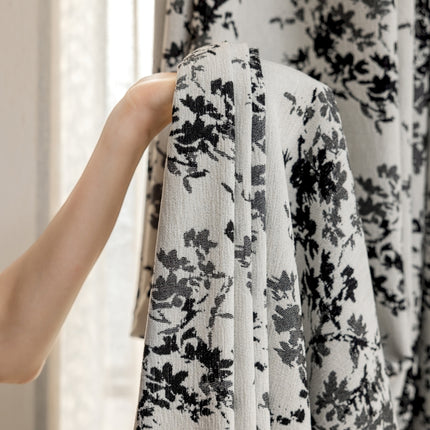 a person is holding up a black and white dress