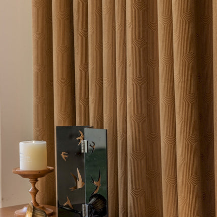 a candle is sitting on a table next to a curtain