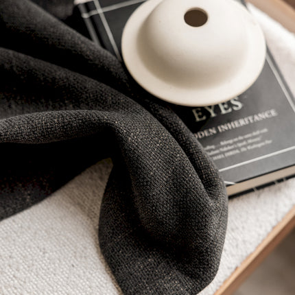 a black scarf and a white button on a table