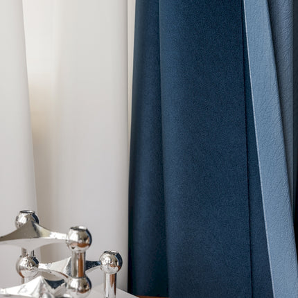 a close up of a faucet with a curtain in the background