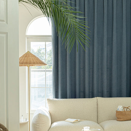 a living room with a white couch and a palm tree