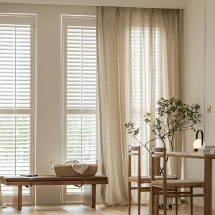 a living room filled with furniture and a window covered in blinds