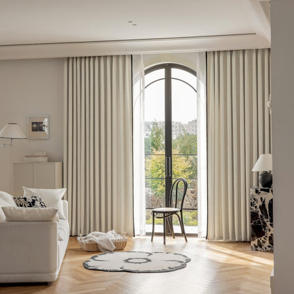 a living room with a white couch a chair and a window