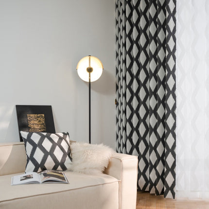a living room with a white couch and black and white curtains
