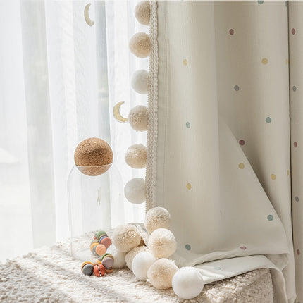 a window with a curtain and some balls on the window sill