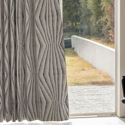 a window with a curtain that has wavy lines on it