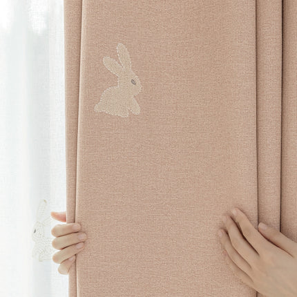 a person is holding a curtain with a rabbit sticker on it