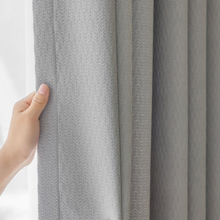 a hand is holding the curtain in front of a window