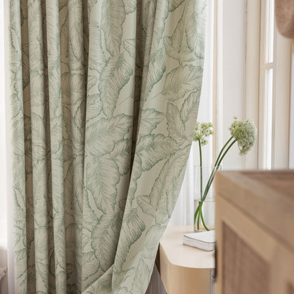 a bedroom with a bed and a window with a curtain