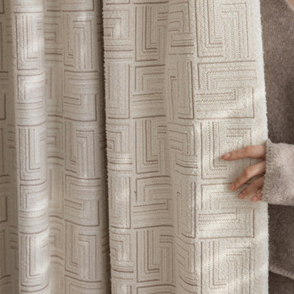 a woman holding onto a curtain with her hand