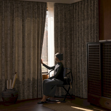 a woman sitting in a chair in front of a window