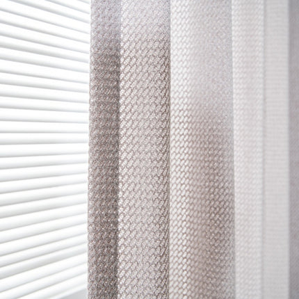 a close up of a curtain with a window in the background