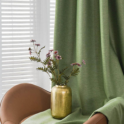 a vase of flowers sitting on a chair in front of a window