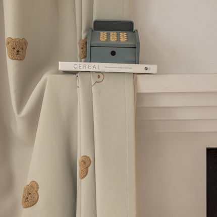 a close up of a curtain with a teddy bear on it