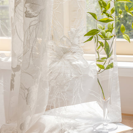 a vase with a plant in it next to a window