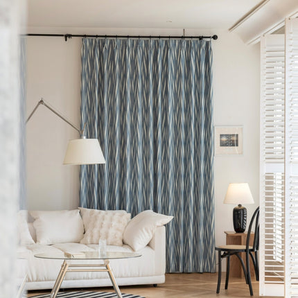 a living room with a white couch and a blue curtain