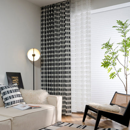 a living room with a white couch and a black and white rug