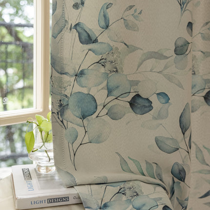 a window with a blue flowered curtain next to a stack of books