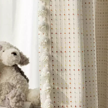 a stuffed dog sitting next to a curtain