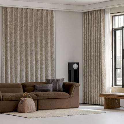 a living room with a brown couch and a clock