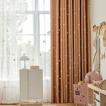 a child's room with a dresser and curtains