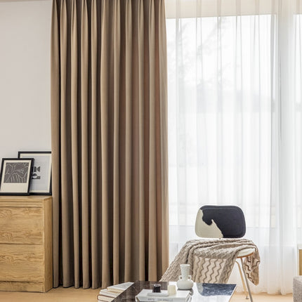a living room filled with furniture and a window covered in curtains